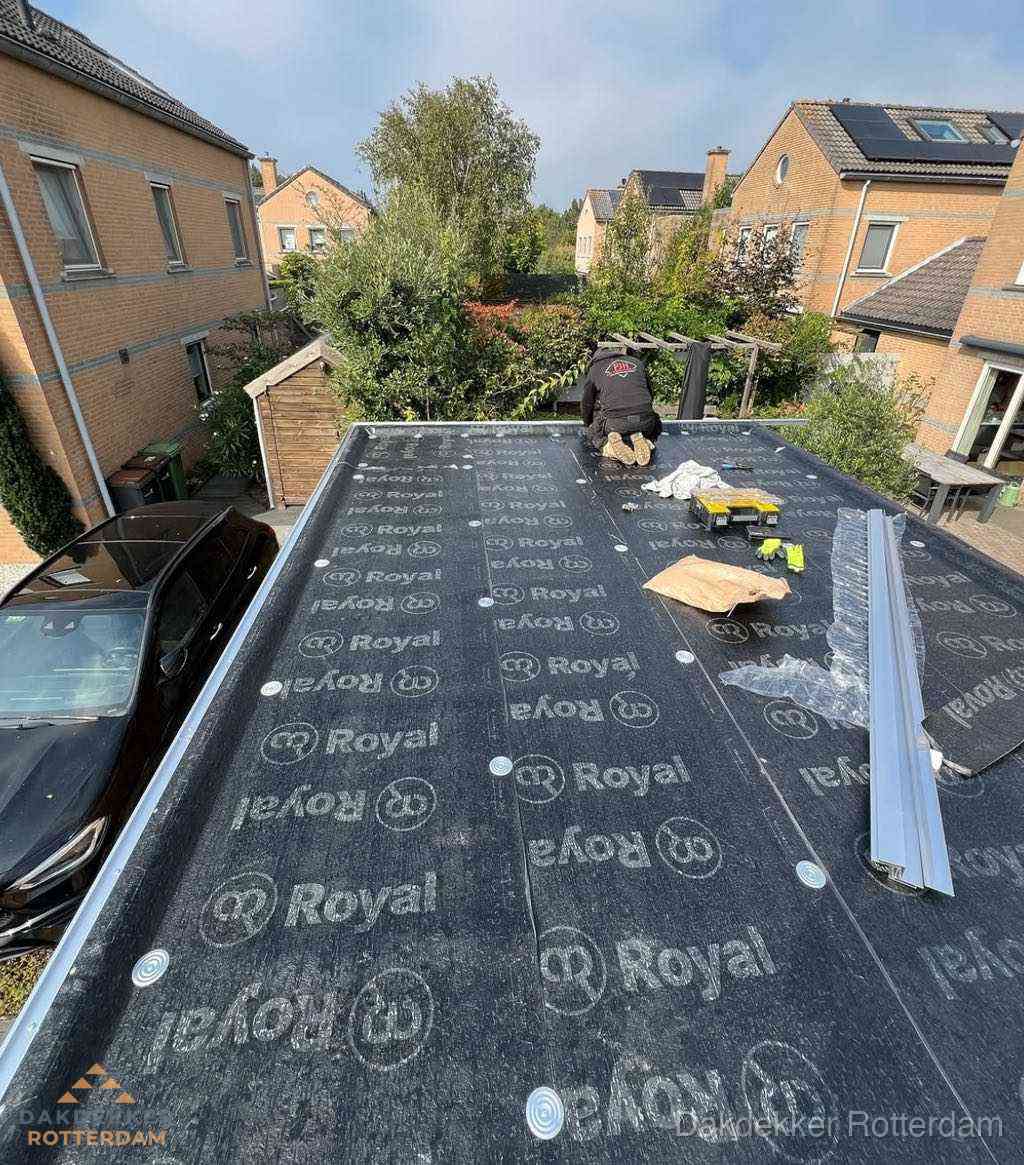 Dakdekker aan het werk op plat dak renovatie in Rotterdam