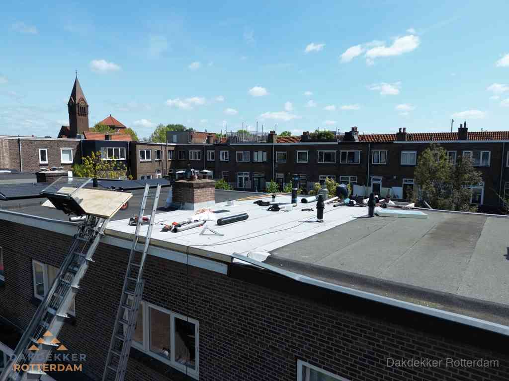 Dakdekkers aan het werk op plat dak in Rotterdam