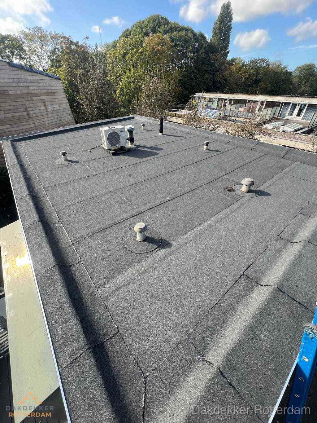 Plat dak met bitumen en brandgereedschap van dakdekkersbedrijf in Rotterdam