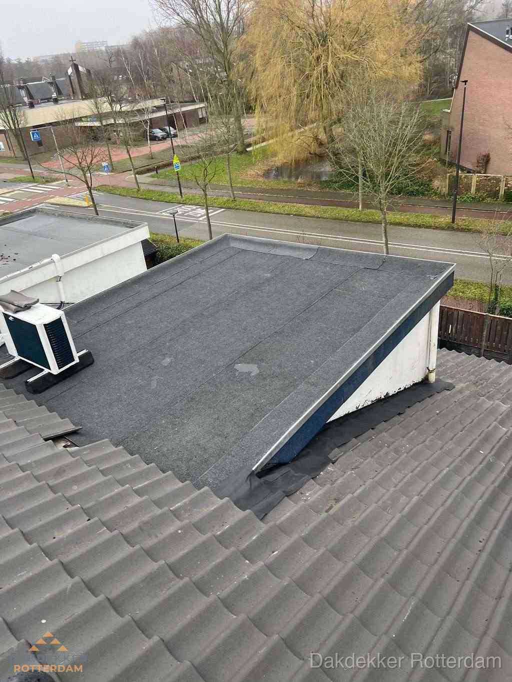 Plat dak met bitumen dakbedekking naast schuin pannendak in Rotterdam