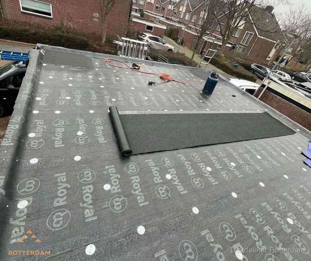 Dakdekker aan het werk met gasbrander op plat bitumen dak in Rotterdam